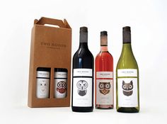 three bottles of wine in front of a brown box with an owl sticker on it