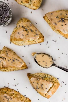 several pieces of bread with peanut butter and lavender sprinkles on them next to a spoon