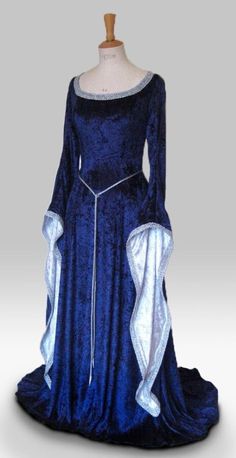 "ISOLDE IS A STUNNINGLY ELEGANT DRESS PICTURED IN NAVY BLUE AND SILVER, ALSO PICTURED IN SILVER AND ROYAL BLUE, BOTTLE GREEN AND IVORY AND PURPLE AND WHITE. DESIGNED AND CUSTOM MADE BY frockfollies AND WOULD BE PERFECT FOR SO MANY OCCASIONS: GOTHIC EVENTS MEDIEVAL/RENAISSANCE/ELVISH WEDDINGS LARP EVENTS RE ENACTMENTS HANDFASTING CEREMONIES LARP EVENTS MASQUERADE  BALLS YOUR INNER GODDESS MOMENTS! HAND MADE IN ENGLAND BY AN EXPERIENCED THEATRICAL COSTUMIER THIS OUTFIT IS AVAILABLE TO ORDER IN A WIDE RANGE OF COLORS. MADE FROM A LUXURIOUS SOFT DRAPEY  NAVY BLUE CRUSHED VELVET, THIS DRESS IS FLUID IN IT'S SIMPLICITY.  THE CLASSIC MEDIEVAL  SLEEVES WHICH ARE  LINED IN SILVER ARE TRIMMED WITH SILVER BRAID AS IS THE FLATTERING CURVED NECKLINE. A SILKY SASH CORD BELT FINISHED WITH SILVER  FILLIGR Elvish Dress, Handfasting Dress, Medieval Wedding Dress, Gothic Gowns, Medieval Gown, Royal Dresses, Fantasy Gowns, Medieval Dress, Medieval Clothing