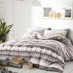 a bed sitting on top of a wooden floor next to a window filled with books