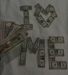 money is laid out on top of a sheet with the word love spelled in it