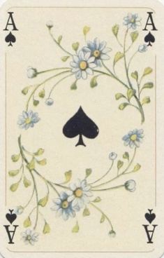 a playing card with blue flowers and leaves on it's sides, in the shape of a ace