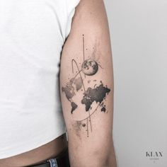 a man's arm with a watercolor world map on it and an arrow in the middle