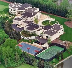 an aerial view of a large mansion with a tennis court