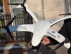 a man holding a white remote controlled flying device