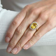 a woman's hand with a yellow and white diamond ring