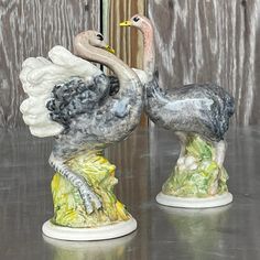 two figurines that look like birds are standing next to each other