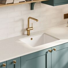 a white sink sitting under a wooden shelf next to a counter top in a kitchen