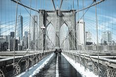 people walking across the brooklyn bridge in winter