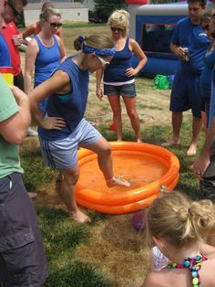 a group of people standing around an orange frisbee