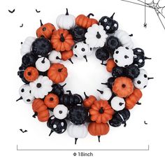 a halloween wreath made out of plastic pumpkins and black and white spider webs