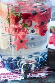 a jar filled with blueberries and strawberries on top of a table