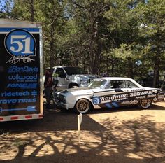 two cars parked next to each other in the dirt