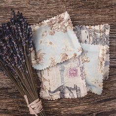 lavender flowers are placed next to an old handkerchief on a wooden table with fabric backings