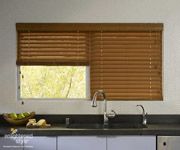 a kitchen with a sink, dishwasher and window covered in blinds on the windowsill