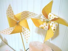 two yellow pinwheels sitting on top of a table