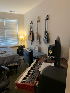 a bedroom with guitars and musical equipment on the wall