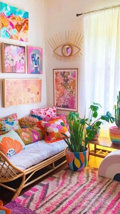 a living room filled with lots of colorful art and plants on the wall next to a couch