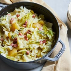 a pot filled with cabbage and potatoes on top of a table