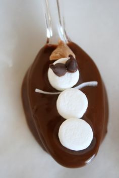 a chocolate ornament with marshmallows in the shape of a snowman