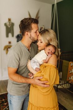 a man and woman holding a baby in their arms