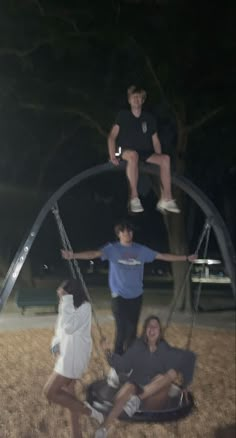 four people are hanging upside down in the air on swings at an amusement park or playground