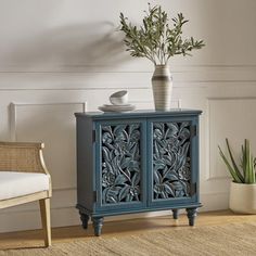 a blue cabinet sitting on top of a wooden floor next to a chair and potted plant