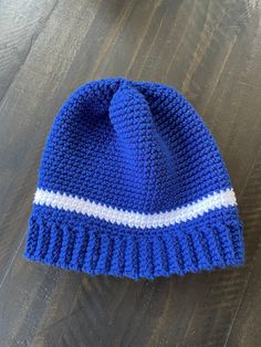 a blue and white knitted hat sitting on top of a wooden table