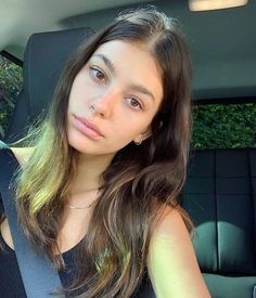 a woman sitting in the back seat of a car with her hand on her hip