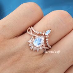 a woman's hand wearing a ring with an aqua blue stone and diamond accents