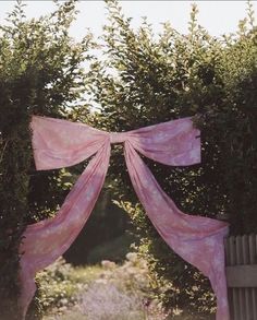 an open gate with pink fabric draped over it