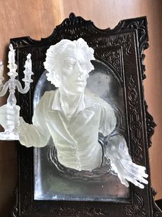 a glass sculpture of a man holding a chandelier