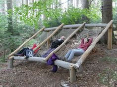 two women laying on a hammock in the woods