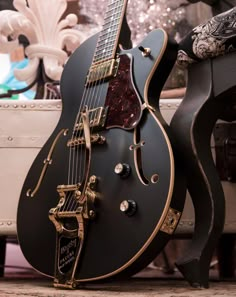 a black and gold guitar sitting on top of a table