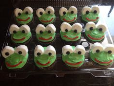 cupcakes with green frosting and white icing are arranged in the shape of frog faces