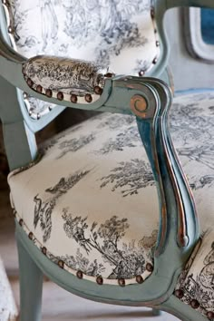 an upholstered chair with blue and white fabric