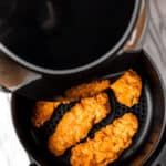 some fried food is being cooked in a frying pan