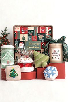 a christmas gift box with candles, cookies and other items