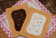 two cookies with sprinkles are sitting on a napkin