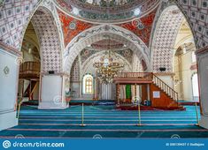 the inside of an ornate building with blue carpet and chandelier hanging from the ceiling