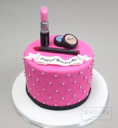 a pink cake with lipstick and makeup on top