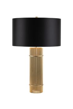 a black and gold lamp with a black shade on the top, it's turned on