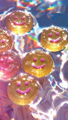 several smiley faces are floating in the water with bubbles on it's sides and one has pink eyes