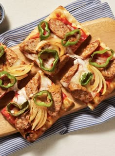 several slices of pizza on a cutting board with onions, peppers and meatballs in them