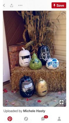 several star wars helmets are sitting on hay bales next to a plant and door