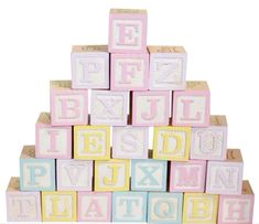 a stack of wooden blocks with letters and numbers painted on the top, in pastel colors