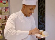 a man in a chef's hat is holding a plate with food on it