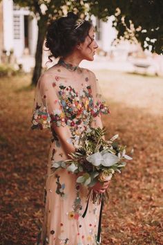 a woman in a floral dress holding a bouquet