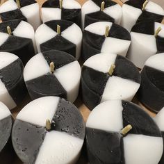 many black and white candles are arranged on a table