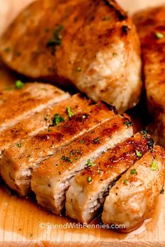 three pieces of meat on a cutting board with parsley sprinkled on top